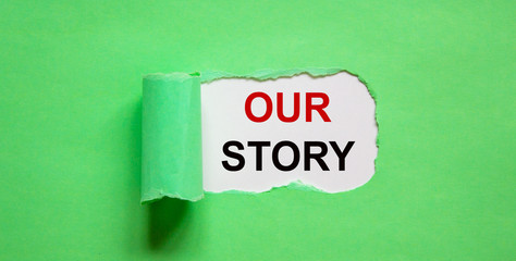 The text 'our story' appearing behind torn green paper. Business concept.