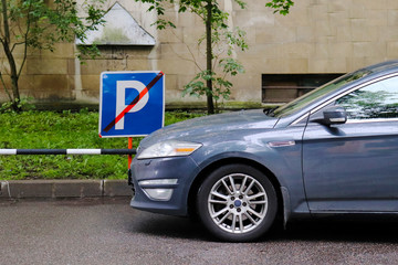 The car is parked in the wrong place. A sign prohibiting Parking.