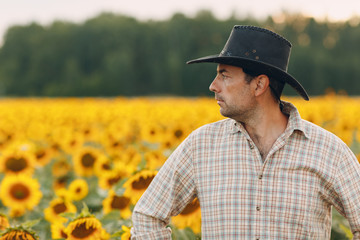 Man farmer standing in a sunflower field