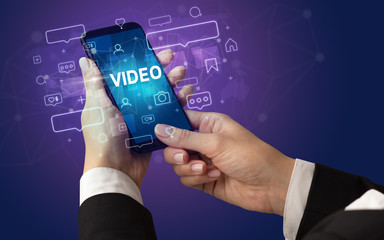 Female hand typing on smartphone with VIDEO inscription, social media concept