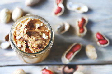 Selective focus. Peanut butter in a jar. Peanuts in the skin.