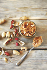 Selective focus. Peanut butter in a jar. Peanuts in the skin.
