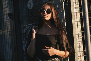 Pretty young sexy fashion model posing on  the street.