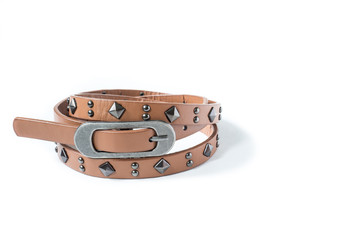 Close-up of thin beige belt with rivets on a white background.