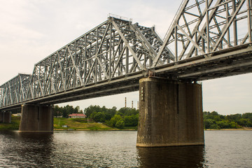 Metal construction-railway bridge over the Volga river in Russia close-up on a cloudy summer day and space for copying