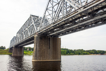 Metal construction-railway bridge over the Volga river in Russia close-up on a cloudy summer day and space for copying