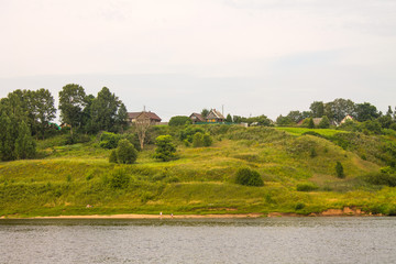 Summer landscape-a beautiful building on a hill and green trees on the banks of the Volga river in Russia on a cloudy day and a space to copy