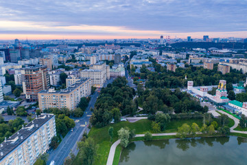 Fototapeta na wymiar green park and houses at dawn view from drone