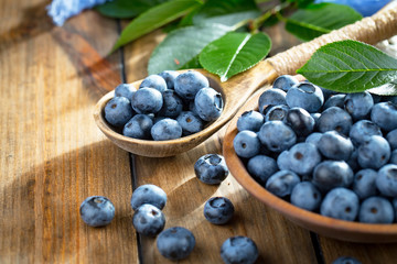 Blueberries in a plate and pancakes, on an old background.