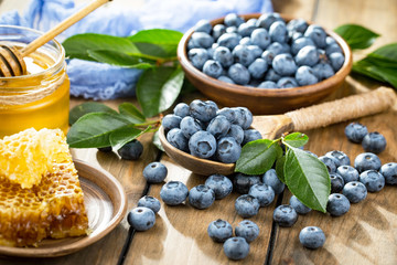 Blueberries in a plate and pancakes, on an old background.