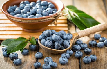 Blueberries in a plate and pancakes, on an old background.