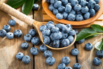 Blueberries in a plate and pancakes, on an old background.