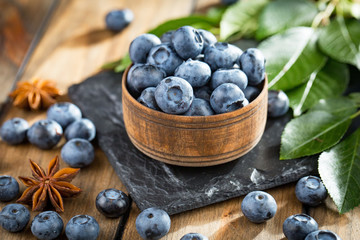 Blueberries in a plate and pancakes, on an old background.