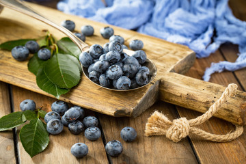 Blueberries in a plate and pancakes, on an old background.