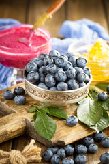 Blueberries in a plate and pancakes, on an old background.