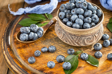 Blueberries in a plate and pancakes, on an old background.