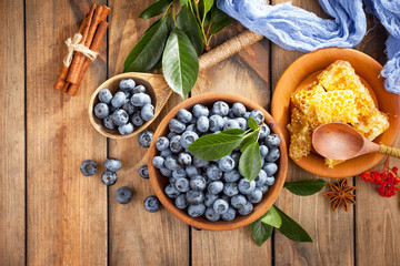 Blueberries in a plate and pancakes, on an old background.