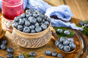 Blueberries in a plate and pancakes, on an old background.