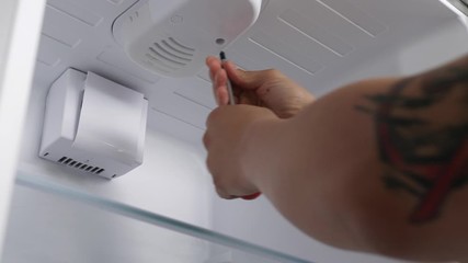 Worker repairing refrigerator, closeup view
