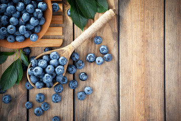 Blueberries in a plate and pancakes, on an old background.