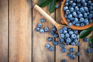 Blueberries in a plate and pancakes, on an old background.