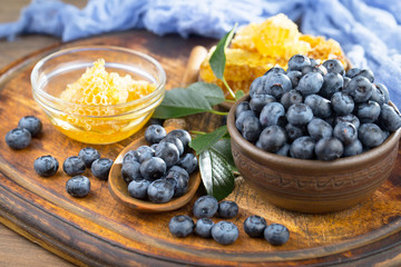 Blueberries in a plate and pancakes, on an old background.