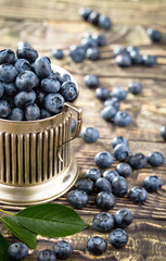 Blueberries in a plate and pancakes, on an old background.