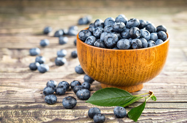 Blueberries in a plate and pancakes, on an old background.