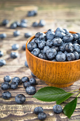 Blueberries in a plate and pancakes, on an old background.