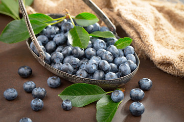 Blueberries in a plate and pancakes, on an old background.