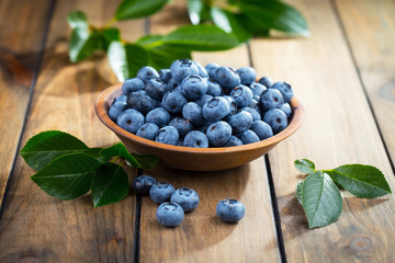 Blueberries in a plate and pancakes, on an old background.