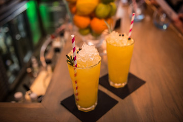 two orange cocktails on bar