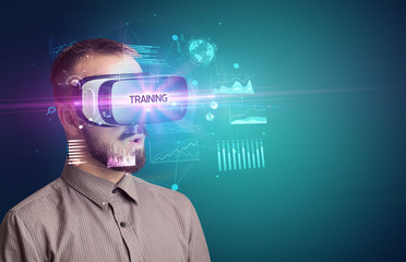 Businessman looking through Virtual Reality glasses with TRAINING inscription, new business concept