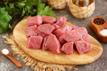 Fresh raw organic beef slices on a cutting board.