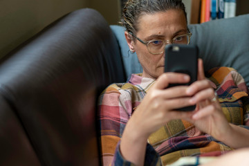 lady on lounge reading/ looking at her phone, foreground focus