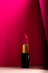 Pink lipstick on modern minimalist background, concept of makeup