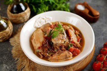 Stewed chicken legs in tomato sauce with onions, garlic and parsley. Top view. 