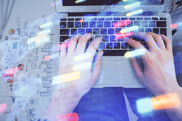 Multi exposure of man's hands typing over computer keyboard and data theme hologram drawing. Top view. Technology concept.