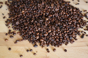 Coffee grains on wooden table, with natural light