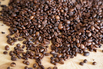 Coffee grains on wooden table, with natural light