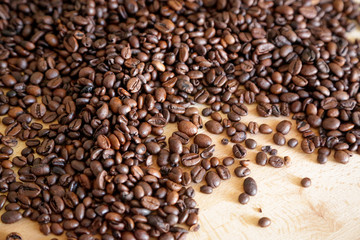 Fototapeta premium Coffee grains on wooden table, with natural light