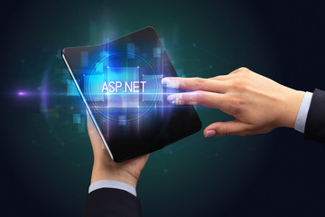 Businessman holding a foldable smartphone with ASP.NET inscription, new technology concept