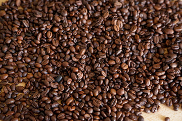 Coffee grains on wooden table, with natural light