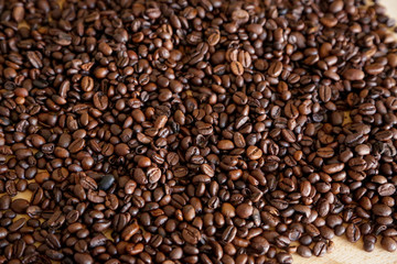 Coffee grains on wooden table, with natural light