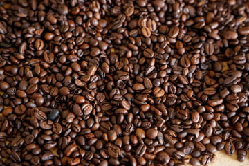 Coffee grains on wooden table, with natural light