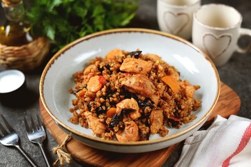 Buckwheat porridge with chicken, prunes, tomatoes, onions and carrots. Healthly food.