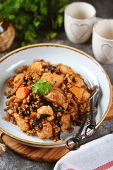Buckwheat porridge with chicken, prunes, tomatoes, onions and carrots. Healthly food.