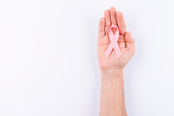 Pink ribbon over palm. White background.