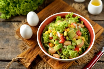 Salad with avocado, corn, beans, onions, bell peppers and lettuce. Healthy vegan food.