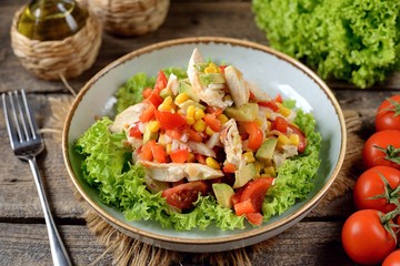 Salad with chicken, cherry tomatoes, avocado, corn, onion, bell pepper and lettuce. Healthly food.